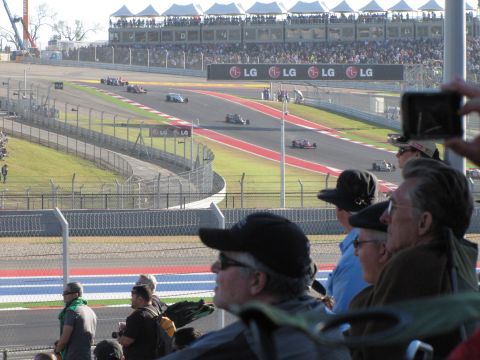 2006 BMW 5 Series - Race cars compete on a track with grandstands full of spectators.