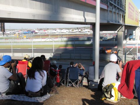 2006 BMW 5 Series - Spectators watch racing cars on a sunny day at a circuit.