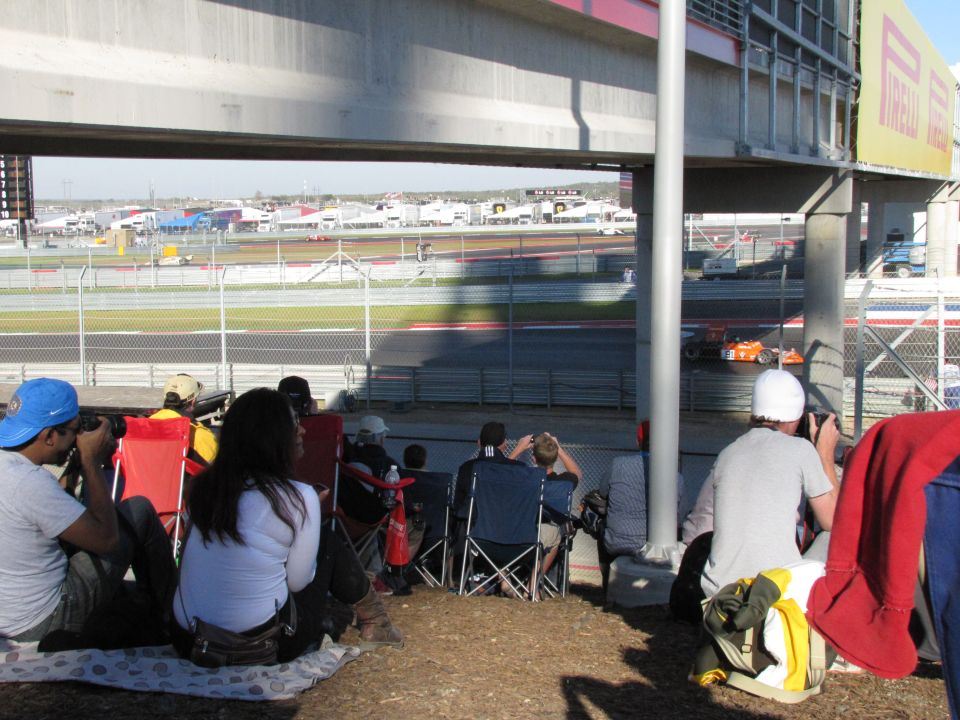 Orange racing car on a track with spectators watching
