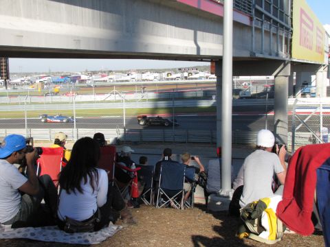 2006 BMW 5 Series - Race cars compete on the track while spectators watch from the sidelines.