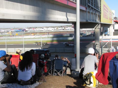 2006 BMW 5 Series - Spectators watch race cars compete on a sunny day at a circuit.