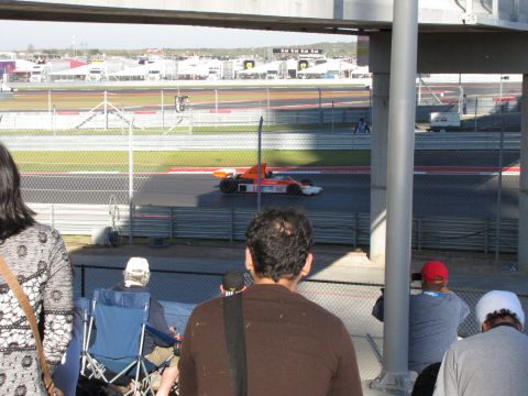 2006 BMW 5 Series - Spectators watch an open-wheel race car during a race event at a circuit.