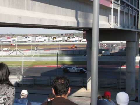 2006 BMW 5 Series - Multiple race cars are competing on a track, viewed from above the stands.