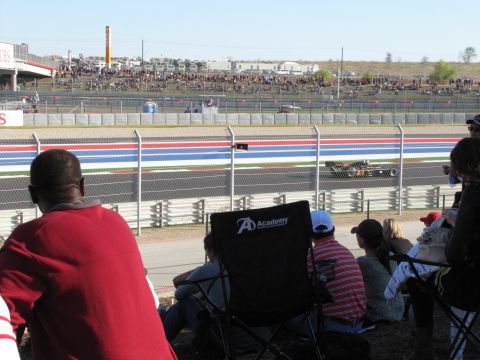 2006 BMW 5 Series - Spectators watch a race car on the track at Circuit of the Americas.