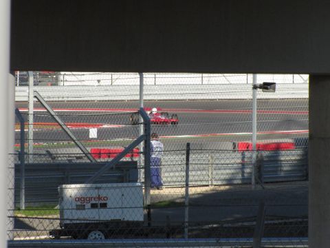 2006 BMW 5 Series - A lone red race car navigates the track, with a generator unit visible in the foreground.
