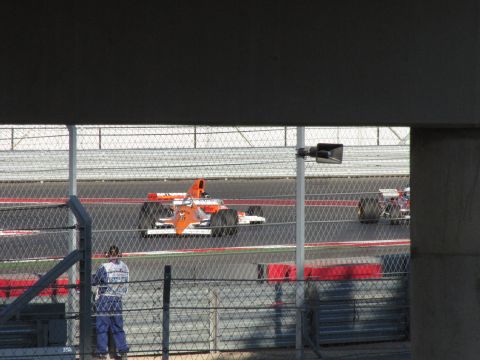 2006 BMW 5 Series - A race car with orange and white livery, number 29, competes on a track alongside another vehicle.
