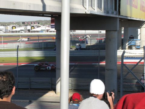 2006 BMW 5 Series - Spectators watch vintage race cars compete on a sunny day at a racetrack.