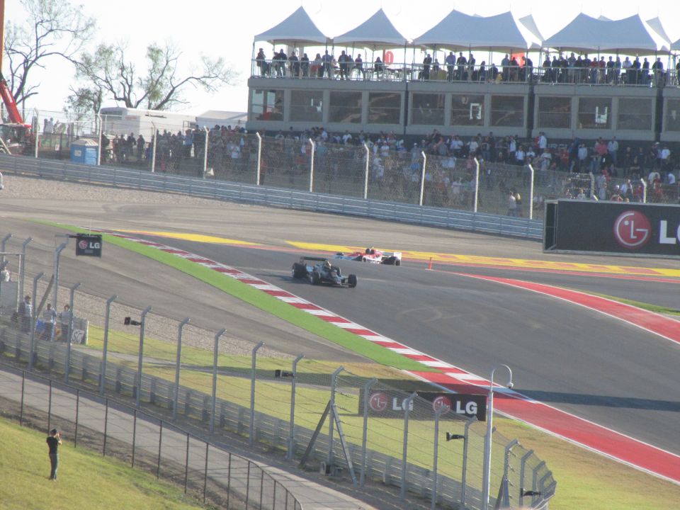 Race cars on a track with spectators in the background and LG branding
