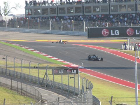 2006 BMW 5 Series - Formula 1 cars compete on a race track, with grandstands filled with spectators and prominent LG advertising.