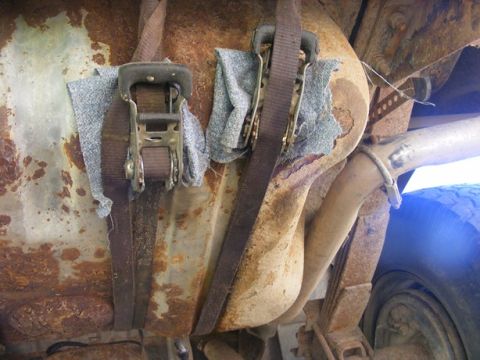 1996 Ford Bronco - Underbody view of a vehicle's fuel tank secured with ratchet straps.