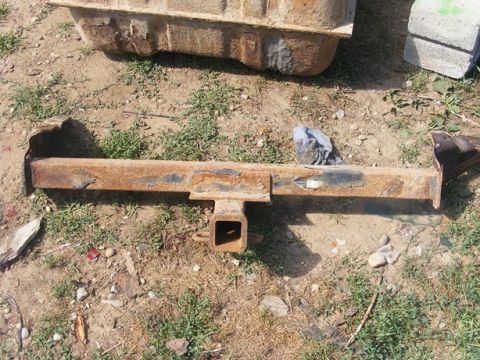 1996 Ford Bronco - A heavily rusted trailer hitch receiver lies on the ground next to a fuel tank.