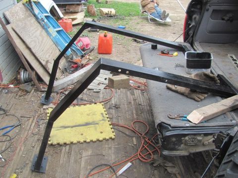 1996 Ford Bronco - A disassembled truck bed rack and various items are laid out on the ground and in the truck bed.