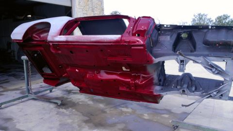 1970 Ford Mustang - The body frame of a 1970 Ford Mustang is shown, painted red and undergoing restoration.