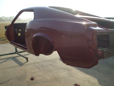 1970 Ford Mustang - The body of a classic car, possibly a 1969 Mustang, is shown on a stand after being painted.