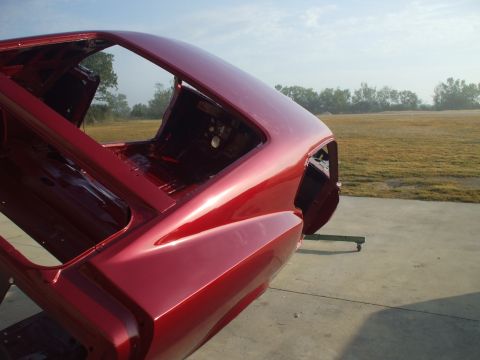1970 Ford Mustang - The metallic red paint on this 1970 Ford Mustang body is visible from a rear three-quarter perspective.