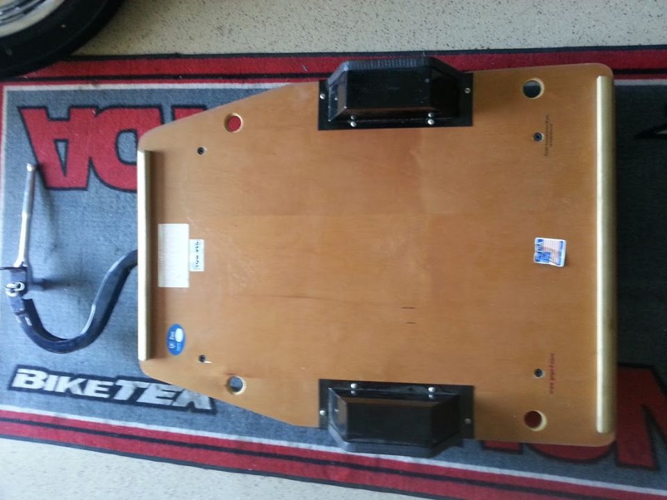 Wooden dolly with black rollers on a mat