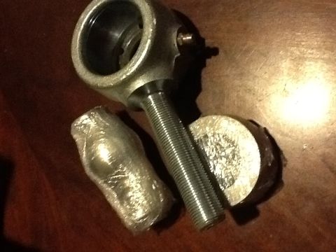 1999 BMW 5 Series - These automotive parts, a tie rod end and ball joint, are shown on a wooden surface.