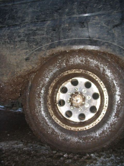 1988 Ford Bronco - A close-up view of a muddy tire and wheel, suggesting off-road use.