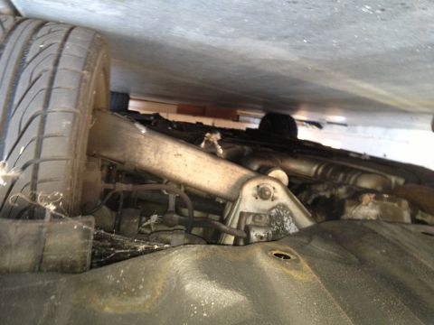 1999 BMW 5 Series - The underside of a vehicle is shown, with a focus on the suspension components and a tire. A watermark for SUPERMOTORS is visible.