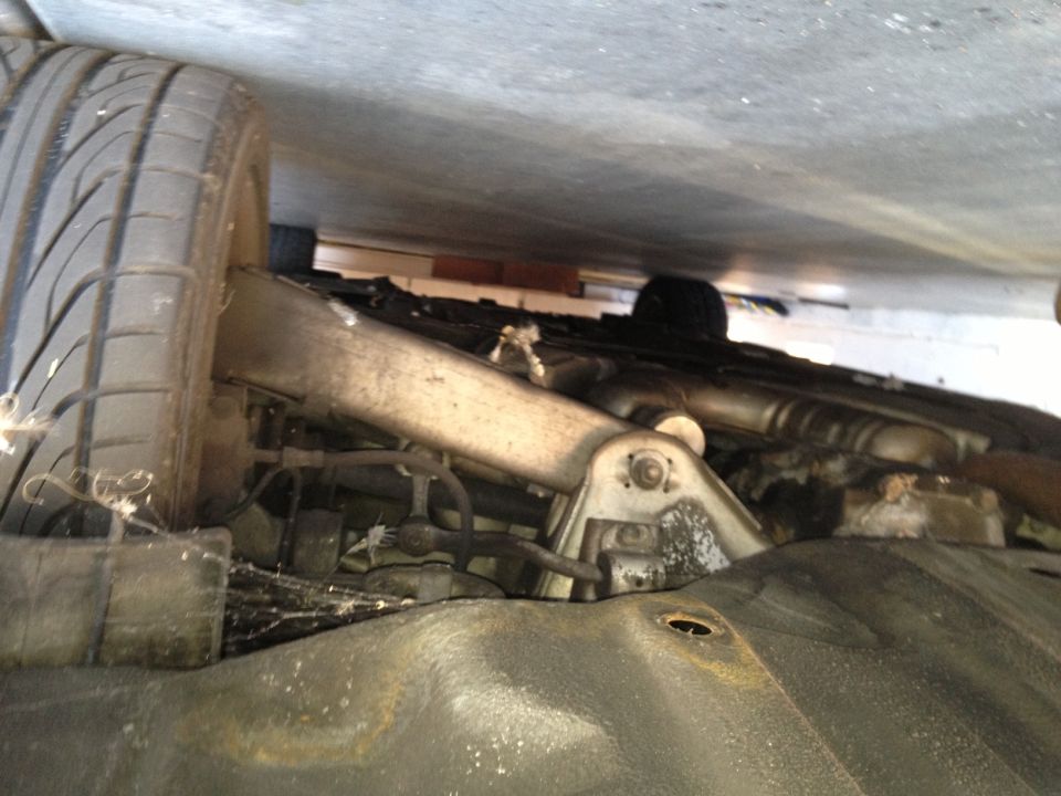 Underside of vehicle showing suspension and tire. Watermark reads SUPERMOTORS