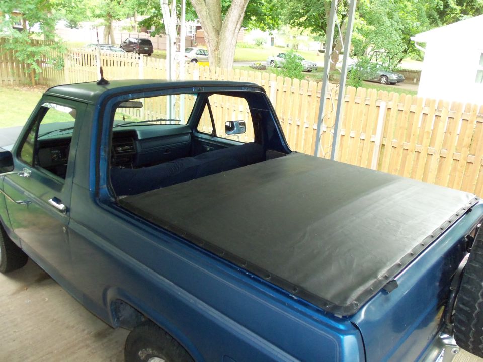 Blue pickup truck with a black tonneau cover, seen from the 3/4 front angle