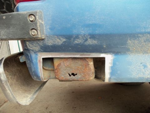1985 Ford Bronco - Close-up of the rear bumper mount on a blue 1985 Ford Bronco, showing rust damage.