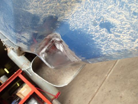 1985 Ford Bronco - A close-up view of a vehicle's undercarriage reveals a newly welded metal bracket and part of the exhaust system.