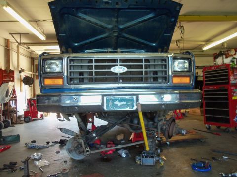 1985 Ford Bronco - This Ford truck is in a garage with its front end disassembled for repairs.
