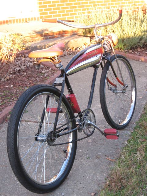 1994 Ford Bronco - A vintage bicycle with a red and chrome gas tank sits on a sidewalk.