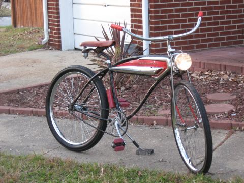 1994 Ford Bronco - A vintage bicycle with red handlebars and pedals sits on a sidewalk.
