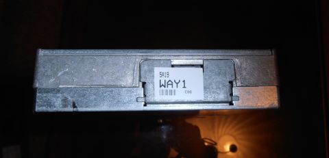 1990 Ford Bronco - Close-up of an engine control unit with a label showing part information and a barcode.