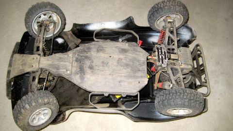 1996 Ford Bronco - The underside of a remote control car chassis is visible, displaying its suspension and mechanical parts.