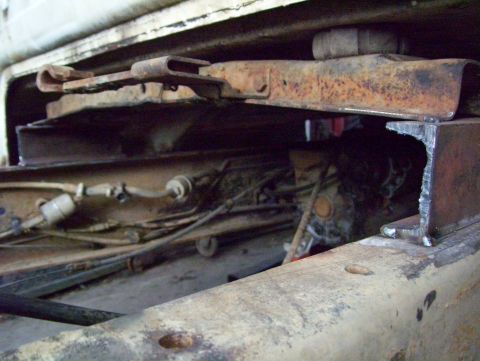 1972 Ford F-150 - Close-up view of the undercarriage reveals rusty frame components and fuel lines on a truck.