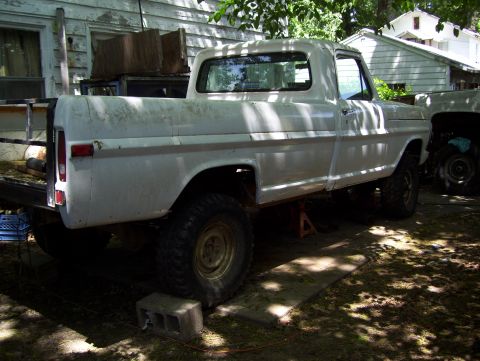 1972 Ford F-150 - Side view of a white Ford pickup truck, possibly from the early 1970s, with another vehicle in the background.