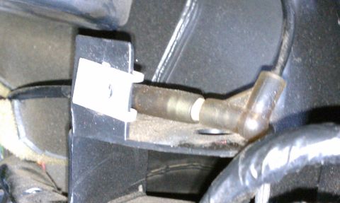 2000 GMC Jimmy - Close-up view of an oxygen sensor and its mounting bracket within a vehicle's interior.