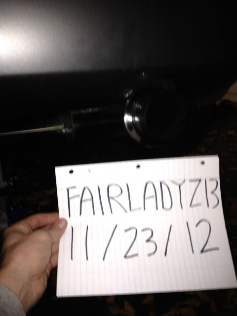 1996 Ford Bronco - Handwritten note 'FAIRLADY ZIB 11/23/12' held in front of an exhaust pipe and muffler.