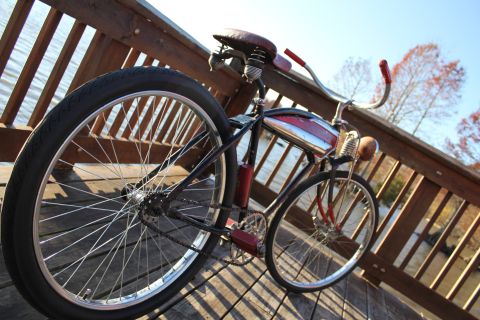1994 Ford Bronco - A vintage cruiser bicycle rests on a wooden boardwalk next to a body of water.