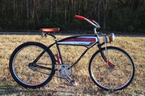 1994 Ford Bronco - A classic bicycle with a distinctive chrome and red tank emblem is parked outdoors on a grassy field.