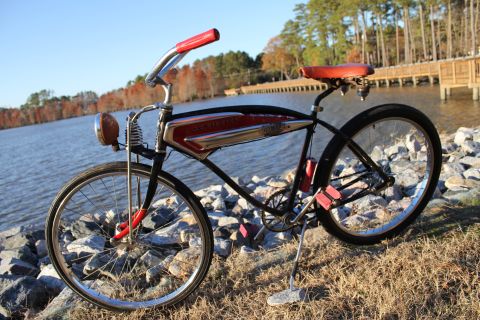 1994 Ford Bronco - A vintage bicycle with red accents sits by the water on a sunny day.