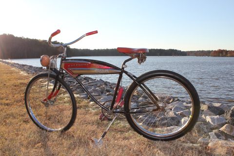 1994 Ford Bronco - A vintage J.C. Higgins bicycle rests on the rocky shore of a lake on a sunny day.