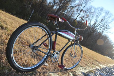 1994 Ford Bronco - A vintage bicycle with a distinctive red and chrome tank is parked outdoors on a grassy slope.