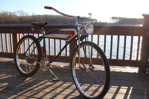 1994 Ford Bronco - A vintage bicycle with a red seat and handlebars is parked on a wooden pier overlooking the water.