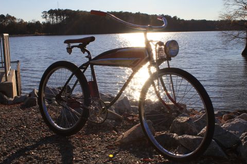 1994 Ford Bronco - A vintage bicycle is parked by the water's edge with the sun glinting off the lake.
