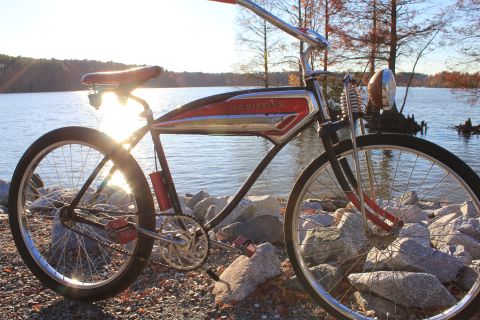 1994 Ford Bronco - A vintage Schwinn bicycle rests on rocks near a lake during sunset.