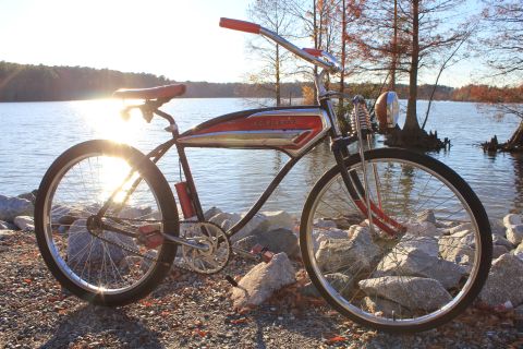 1994 Ford Bronco - A vintage red and chrome Schwinn bicycle sits by the water's edge on a sunny day.