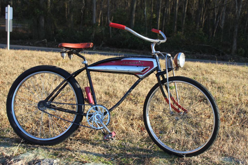 Side view of a vintage black bicycle with red accents and a chrome tank