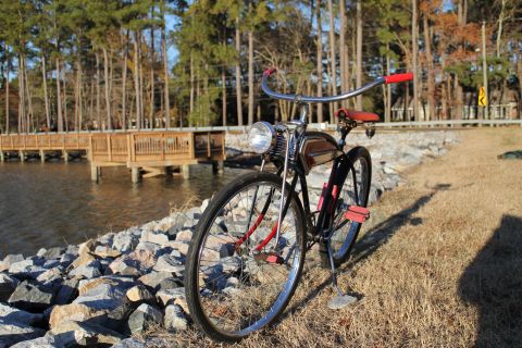 1994 Ford Bronco - A vintage bicycle with a headlight sits by the water on a sunny day.
