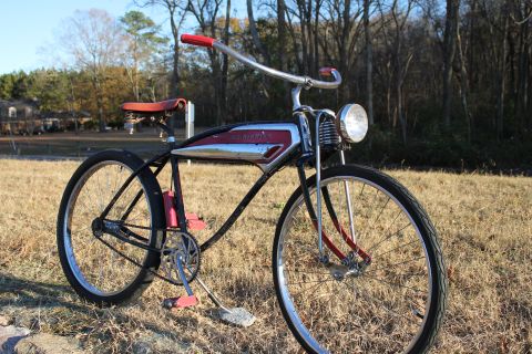 1994 Ford Bronco - A vintage bicycle with a distinctive chrome and red gas tank sits outdoors in dry grass.