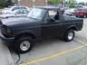 1994 Ford Bronco - This black Ford Bronco, likely from the early 1990s, is captured from a 3/4 front perspective.