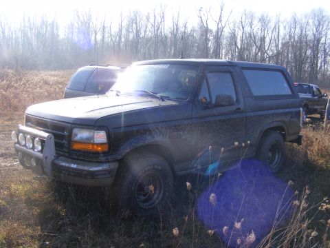 1996 Ford Bronco - This 1996 Ford Bronco is seen in a field with another vehicle in the background.